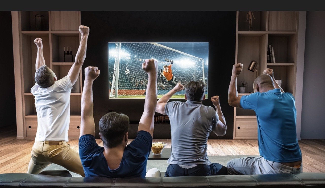 Family watching a soccer match together at home